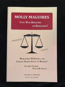 Book cover with red and white design featuring a scale of justice and text about the guilt or innocence of James McDonnell and Charles Sharpe.
