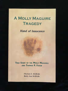 Tan book cover with ghostly handprint image and green text reading “A Molly Maguire Tragedy – Hand of Innocence.”